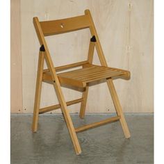 a wooden folding chair sitting in front of a wall