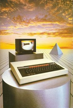 an old computer sitting on top of a table next to a keyboard and monitor with pyramids in the background