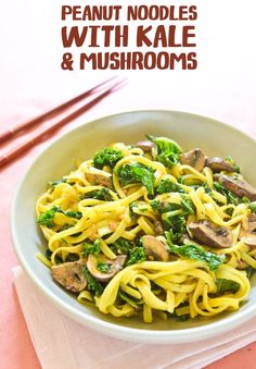 a bowl filled with noodles and broccoli on top of a pink table cloth