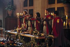 a group of people standing around a table with candles