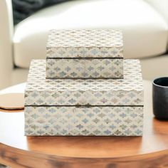 three boxes sitting on top of a wooden table next to a cup and saucer