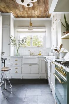 a kitchen with white cabinets and an oven in the center is featured on instagram