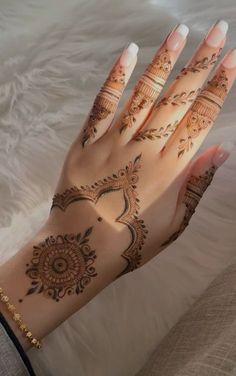 a woman's hand with henna tattoos on it