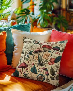 a bunch of pillows sitting on top of a bed in front of some potted plants