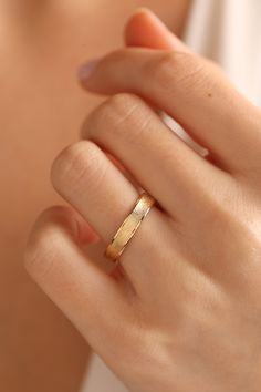 a woman's hand with a gold ring on it