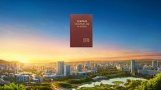 a book that is sitting on top of a hill in front of a cityscape