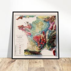 a framed map of the united states and canada on a wooden floor in front of a white wall