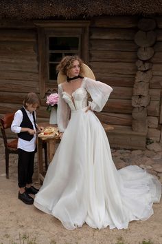 a woman in a wedding dress standing next to a little boy