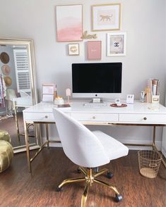 a white desk topped with a computer monitor next to a gold framed wall mounted mirror