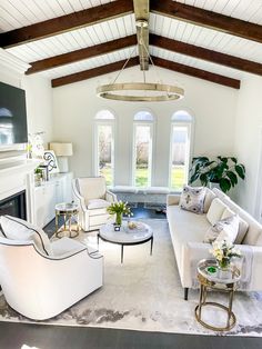 a living room filled with furniture and a fire place in the middle of an open floor plan