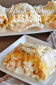 two white plates topped with lasagna covered in cheese and sauce, on top of a wooden table