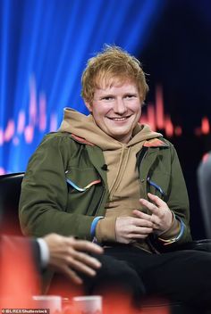 a man sitting in a chair smiling at the camera