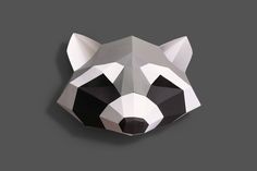 an origami raccoon head is shown on a gray background with black and white accents