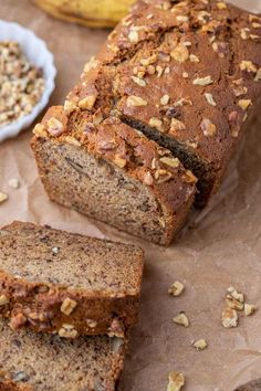 sliced loaf of banana nut bread on top of brown paper