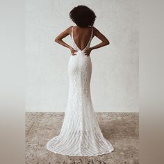 the back of a woman's wedding dress, with her hands on her hips