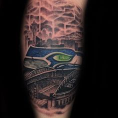 a man's arm with an eye and cityscape tattoo on it,