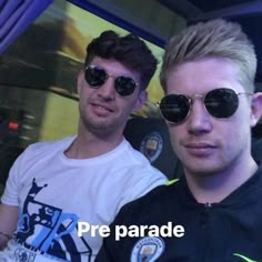 two men wearing sunglasses are posing for a photo in front of a window with the words pre parade on it