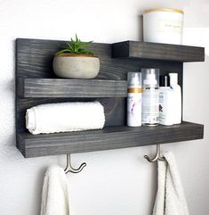 a bathroom shelf with two shelves holding personal care items and a potted plant on top