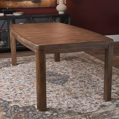 a wooden table sitting on top of a rug