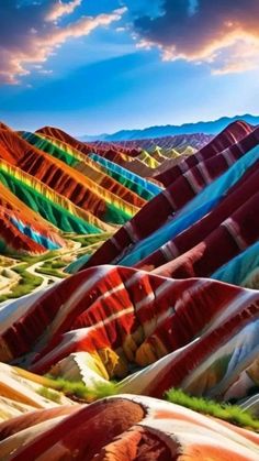 the colorful hills are painted with different colors and shapes, as well as clouds in the sky