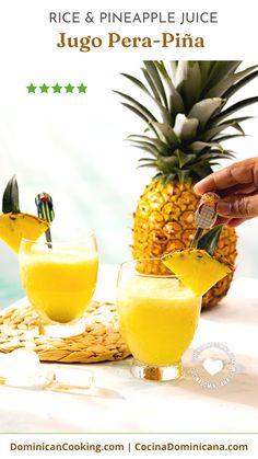 a pineapple juice is being poured into two glasses