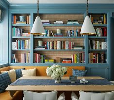 a dining room table and chairs with bookshelves in the background