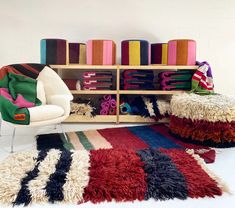 a colorful rug and chair in front of a bookcase with books on it's shelves