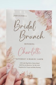 a woman holding up a bridal brunch card with flowers on the front