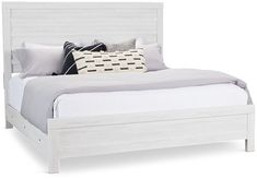 a white bed with two pillows on top of the headboard and foot board is shown