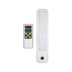 a remote control sitting next to a white object on a white surface with two different colored lights