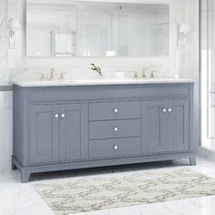 a bathroom with two sinks and a large mirror on the wall above it, along with a rug