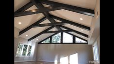 an empty room with high ceilings and wooden beams on the ceiling is pictured in this image