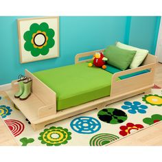 a child's bed with green sheets and pillows in a blue walled children's room