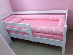 a pink and white toddler bed in a room