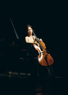 a woman is playing an instrument in the dark