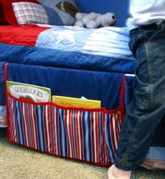 a person standing next to a bed in a room with red, white and blue bedspread