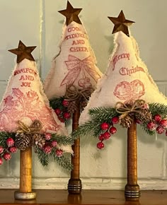 three small christmas trees on top of a wooden table