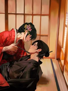 two people in kimonos sitting on the floor and one is brushing his teeth