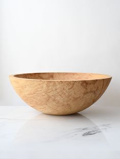 a wooden bowl sitting on top of a white counter