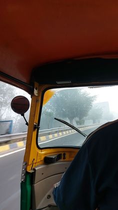 a man driving a yellow truck down a street