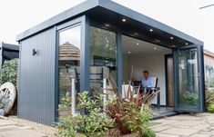 a man sitting at a table in the back of a small building with glass doors