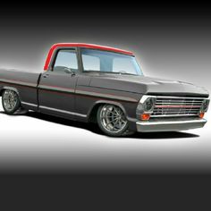 an old gray truck with red trim parked in a dark room on a grey background