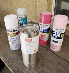 several cans of paint sitting on top of a wooden table