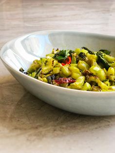 a white bowl filled with food on top of a table