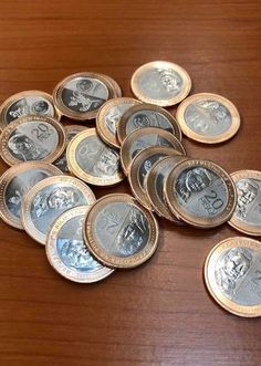 a pile of coins sitting on top of a wooden table