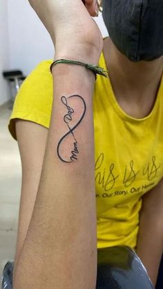 a woman with a tattoo on her arm and the word love is spelled in cursive writing