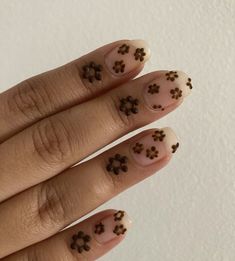 a woman's hand with brown flowers on it