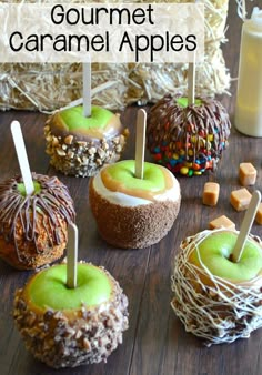 an assortment of caramel apples sitting on top of a wooden table