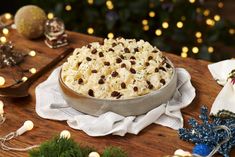 a pie sitting on top of a wooden table next to christmas decorations and lights in the background