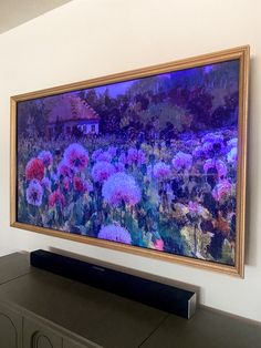 a large painting hanging on the wall above a tv